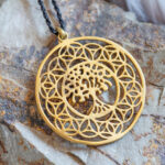 Médaille de baptême : pourquoi choisir un motif arbre de vie ? Brass pendant in the shape of mandala tree on rocky background