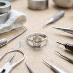 Faire ajuster une bague en argent 925 trop grande sans risquer sa pierre Bague en argent 925 avec pierre protégée, posée sur un établi de bijoutier avec des outils de précision pour son ajustement.