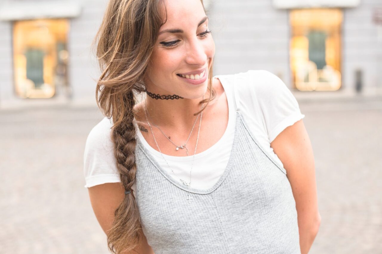 Femme portant un collier charm composé de plusieurs pendentifs assortis.